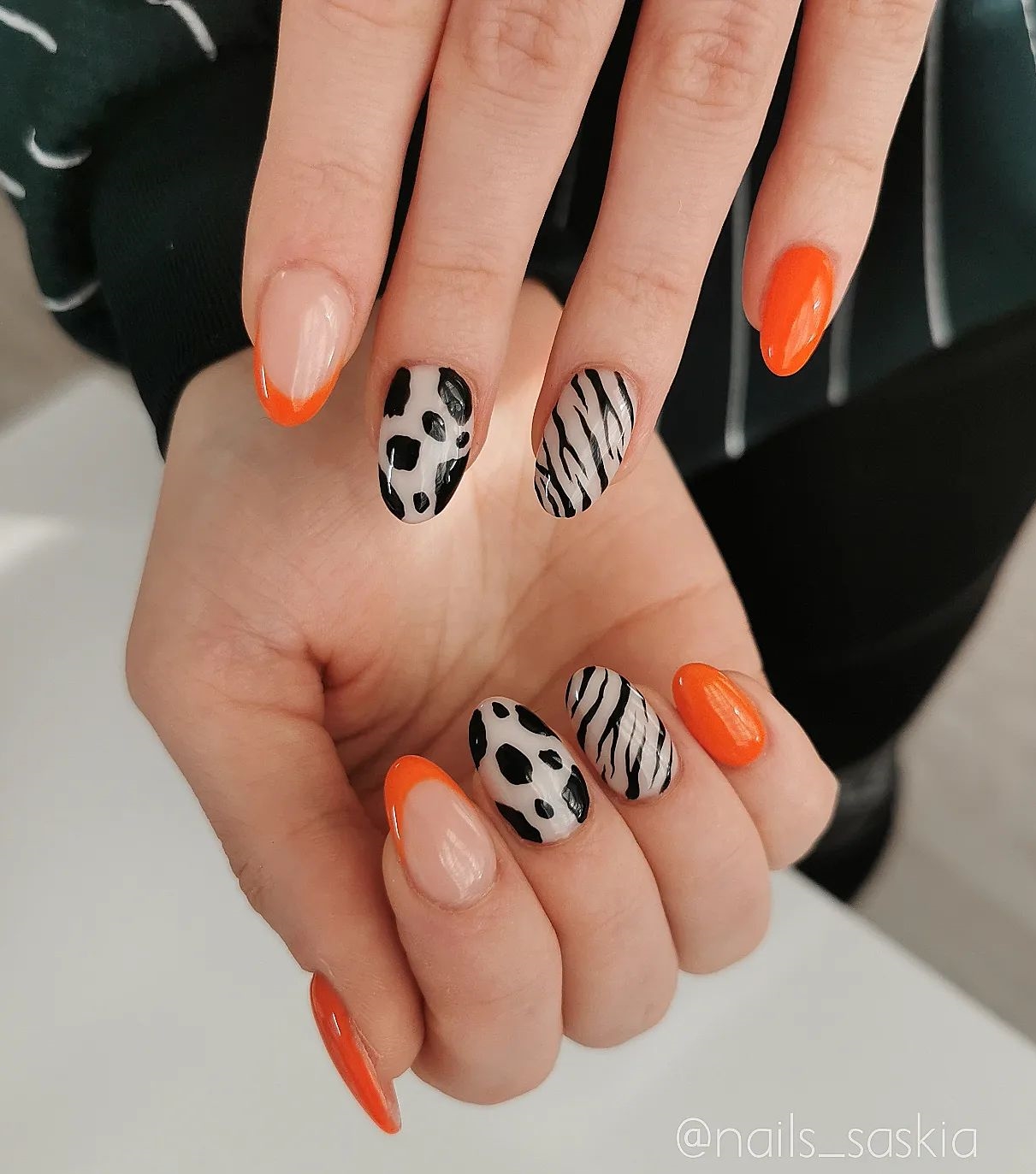 Short Round Orange Nails with Black and White Cow Print Design