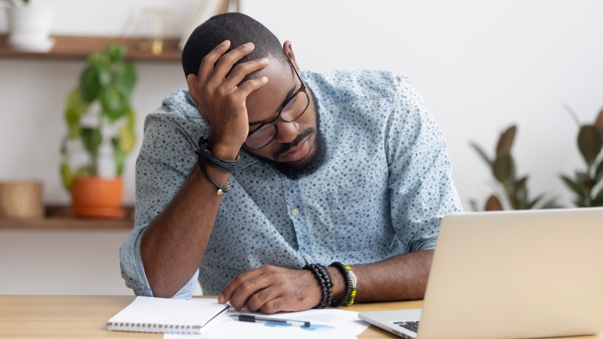 An engineer sitting in front of a computer trying to find CAD design data.